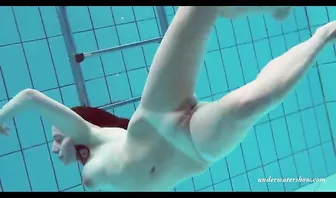 Рыжеволосая сучка голой ныряет под водой показывая свои прелести